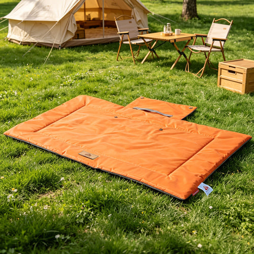 Orange foldable outdoor pet travel mat at a campsite